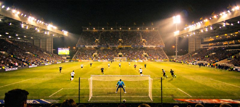 夜间体育场灯火通明的足球比赛现场全景画面